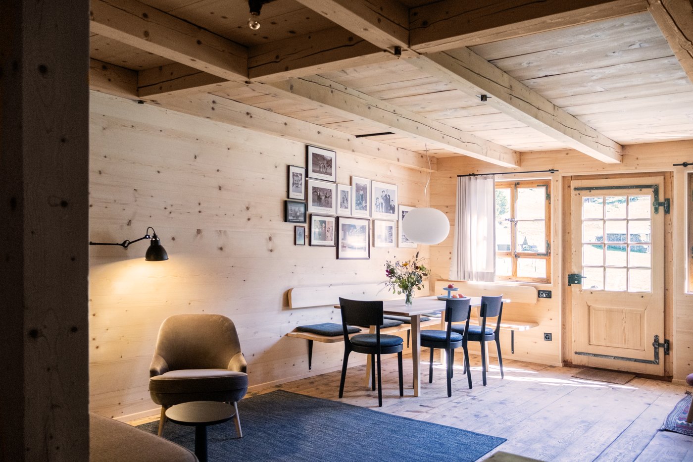 Wohnraum im Berghaus Steinenberg mit Holzwänden, Esstisch und Wandbank