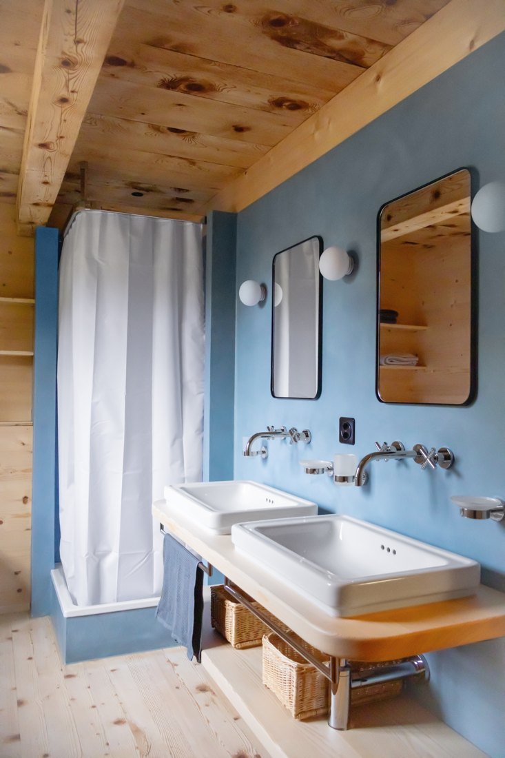 Blaues Bad mit Holz, zwei Lavabos und Metallspiegeln