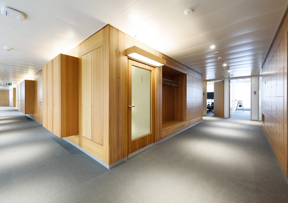Mit Holz verkleideter Gebäudekern und angrenzende Arbeitsbereiche im AXA-Bürogebäude