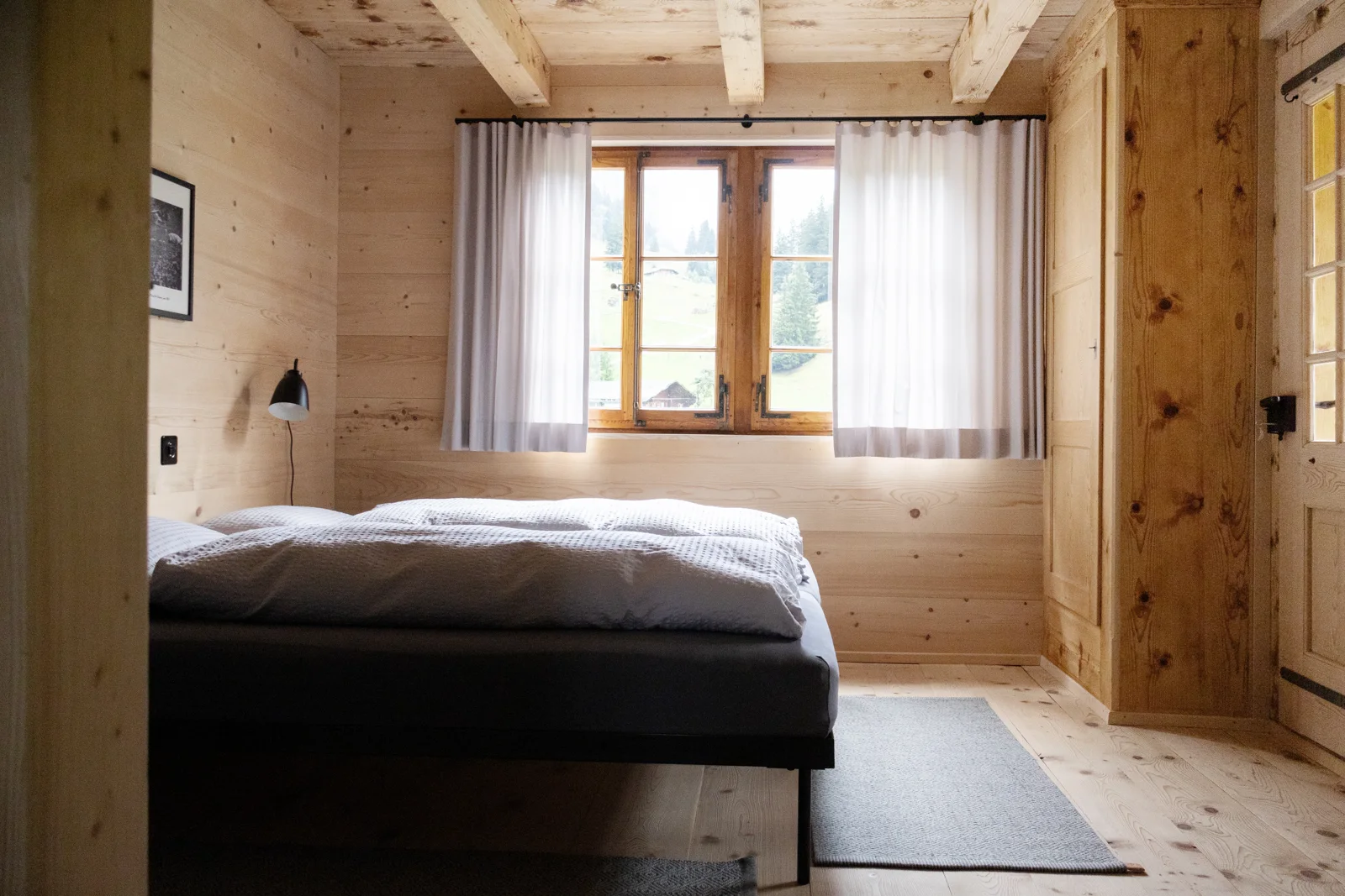 Schlafzimmer mit Holzoberflächen und Blick zum Fenster