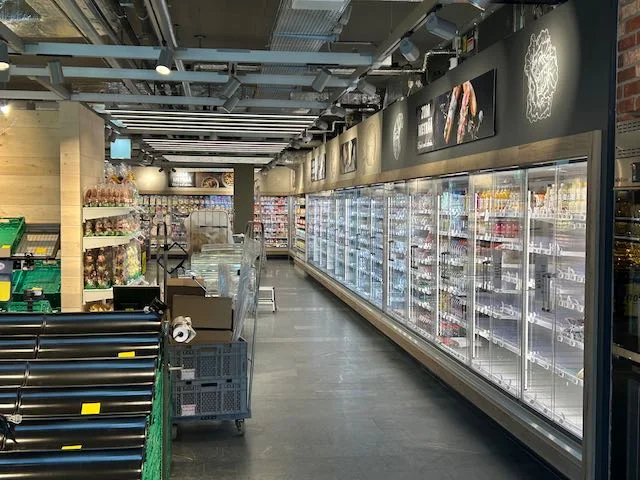 Kühlmöbel und sichtbare Installationen prägen den Verkaufsraum
